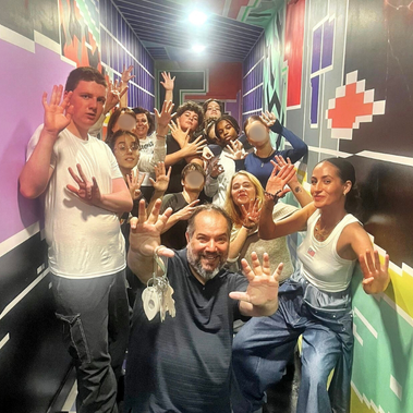 Orphelins d'orphéopolis et animateurs réunis dans une salle coloré. Tous sourient et saluent la caméra