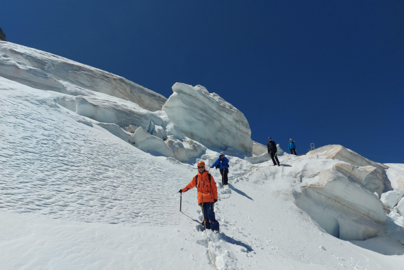 Orphelins d'Orphéopolis descendant un glacier avec des crevasses visibles à proximité.