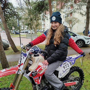 Une protégée d'Orphéopolis sur une moto.