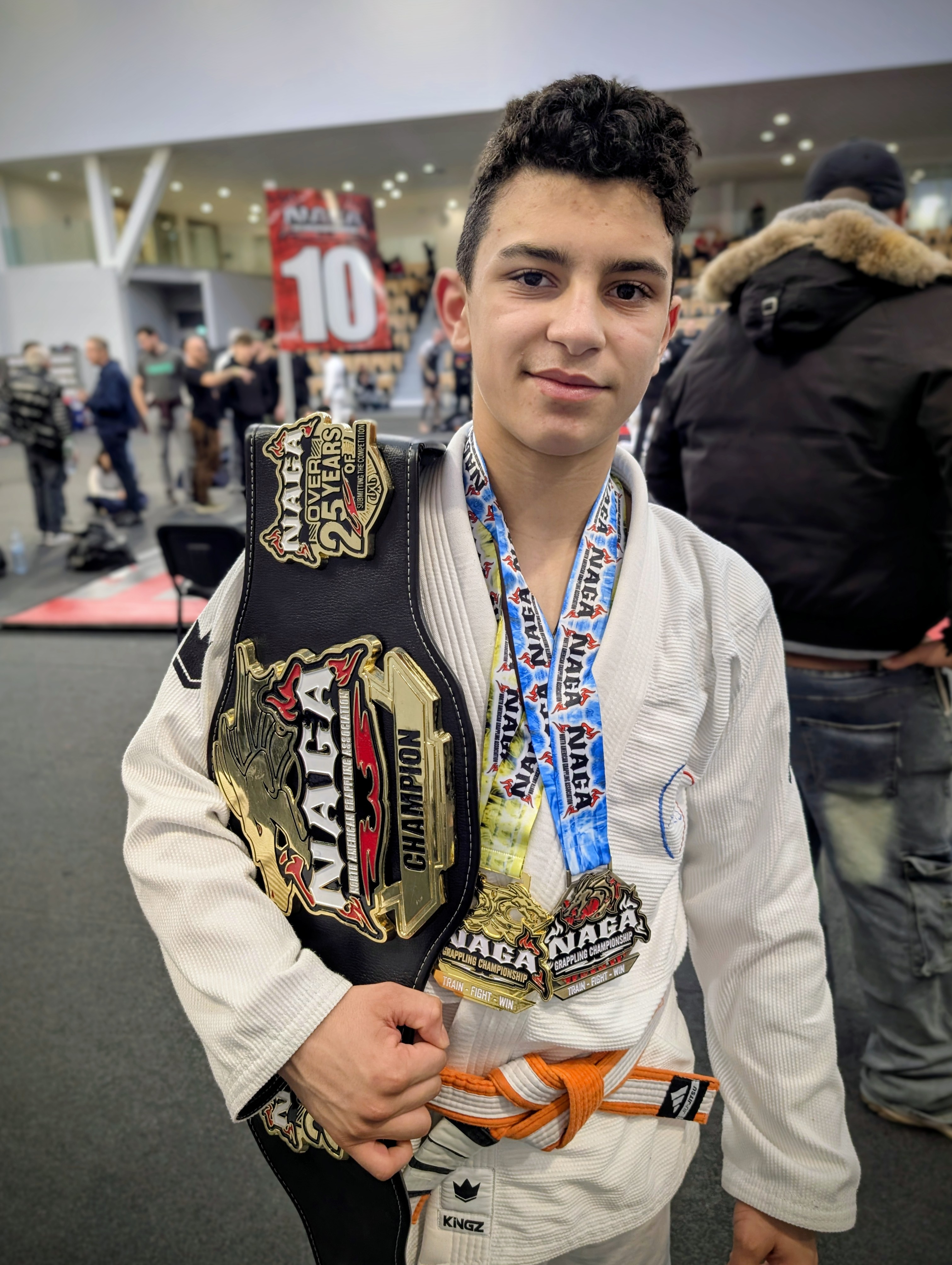 Mathis posant avec les médailles et la ceinture qu'il vient de gagner