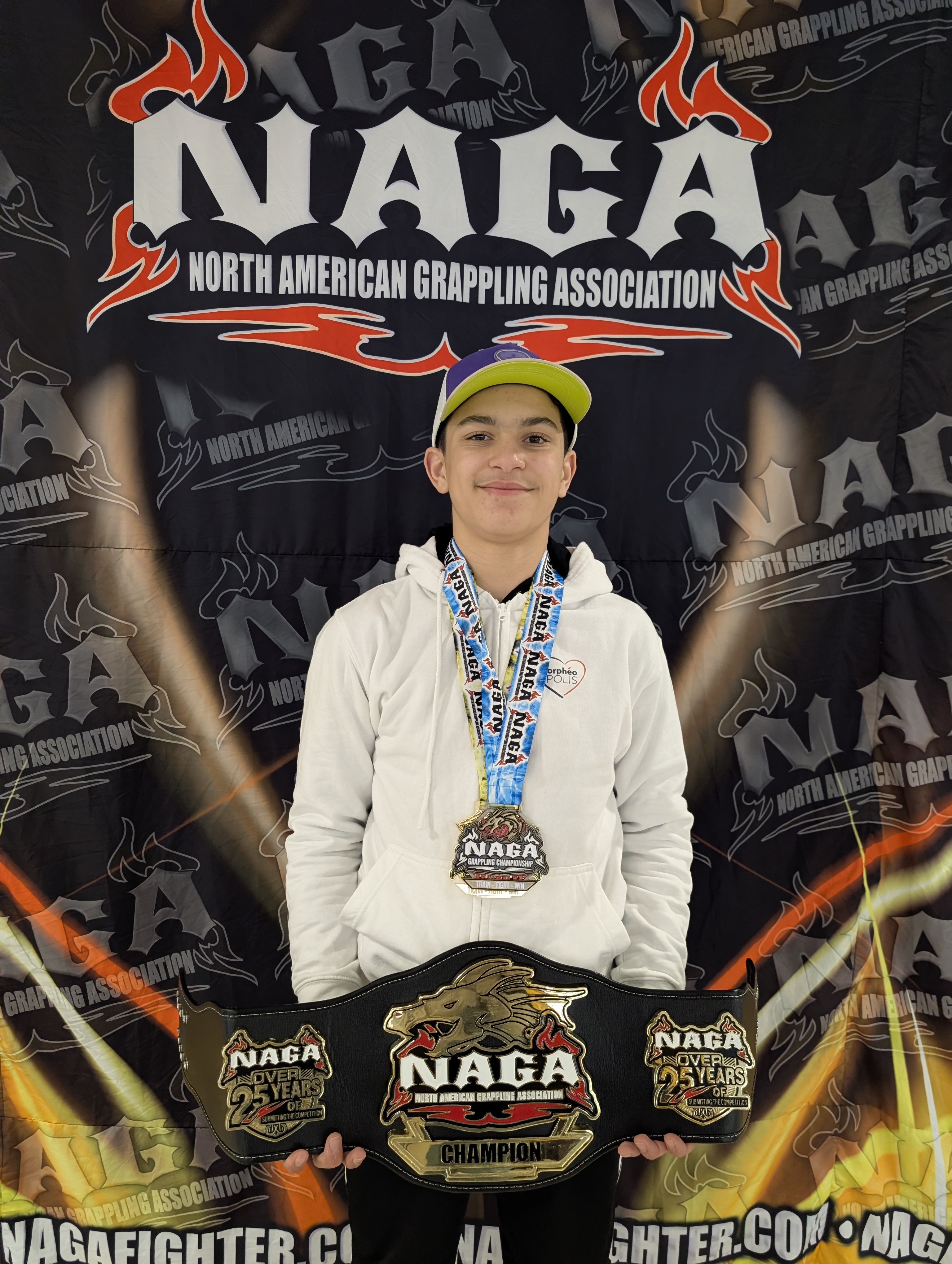 Mathis posant avec les médailles et la ceinture qu'il vient de gagner