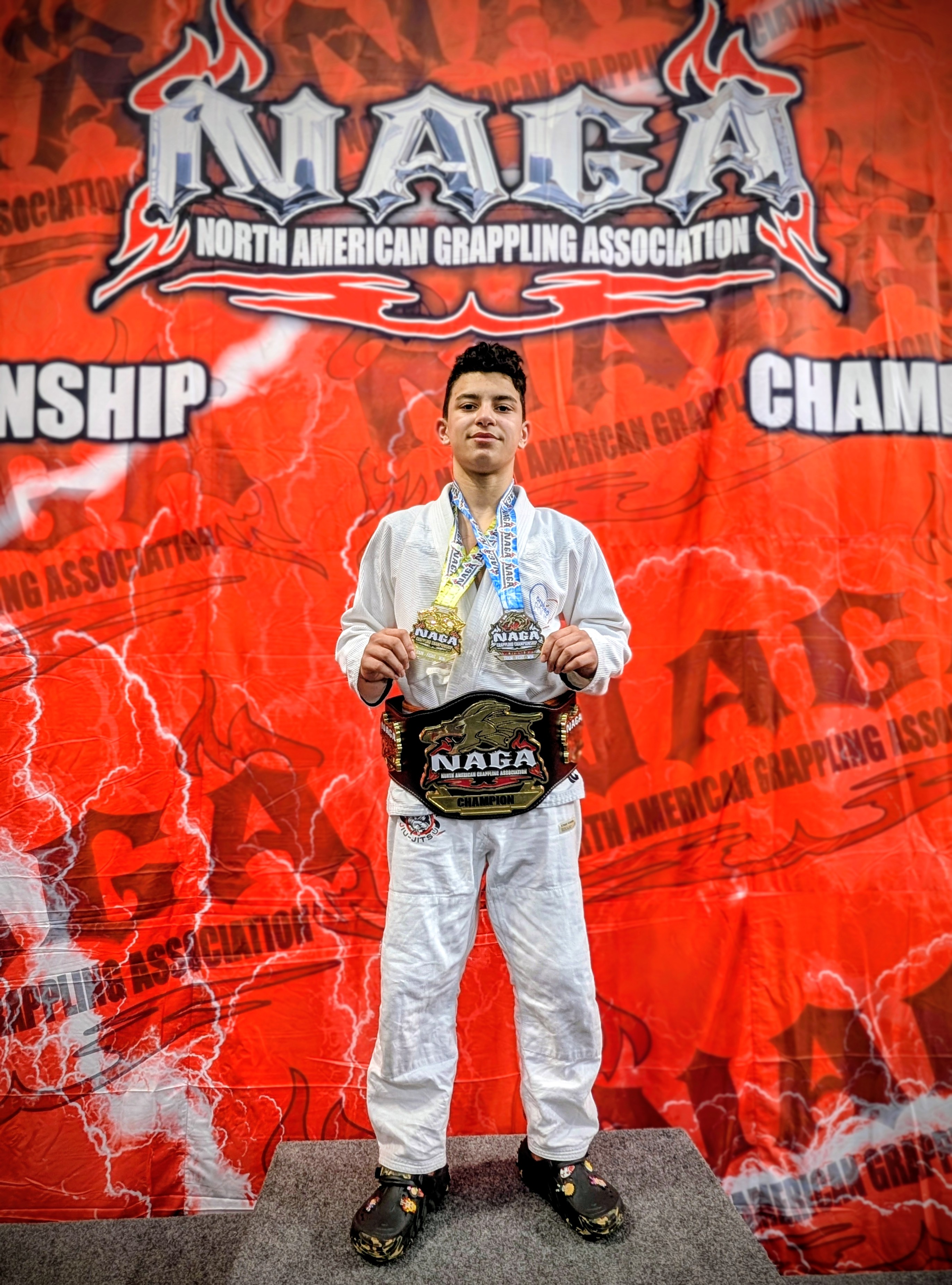 Mathis posant avec les médailles et la ceinture qu'il vient de gagner