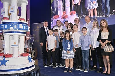 Le président d'Orphéopolis, les orphelins et les grands chefs devant le gâteau d'anniversaire