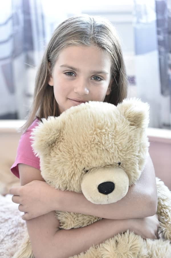 orpheline tenant un gros nounours dans ses bras
