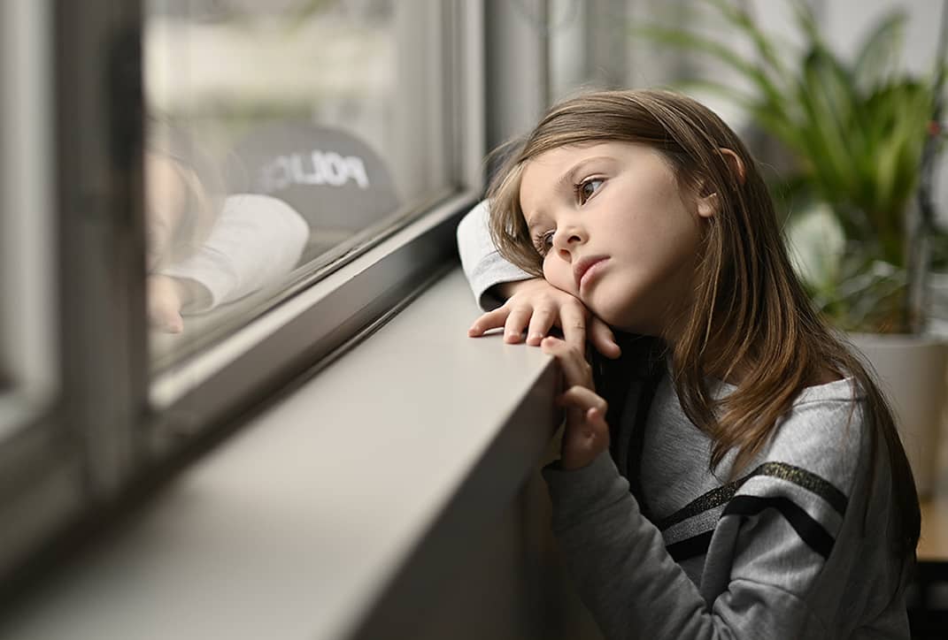 Orpheline qui regarde par la fenêtre